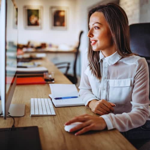 Beraterin von CC Consulting am Arbeitsplatz, fokussiert am Computer, bereit für professionelle Kundenberatung und digitale Lösungen.