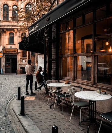 Mitarbeiter im Gespräch vor dem Café an der Straße.